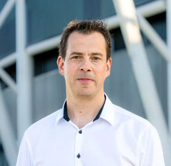 Main with short brown hair and wearing a white shirt
