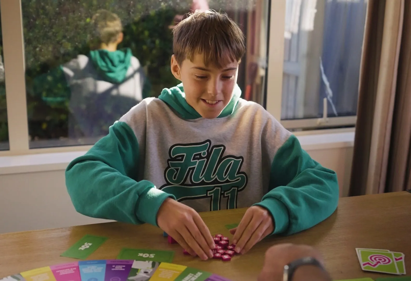 A boy grinning as he gathers a pile of share blocks during a game of Sharenanigans